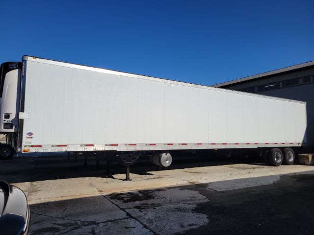 Impact view of a white utility reefer trailer with Tri-axle wheels, landing gear, and minimal visible branding; side text is faint.
