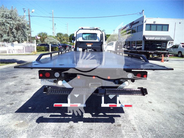 Isuzu FTR tow truck flatbed rear view showing platform and wheel lift with lights and rails.