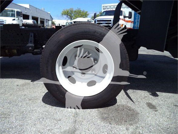 Isuzu NRR truck wheel and front suspension visible in side-angle photo.