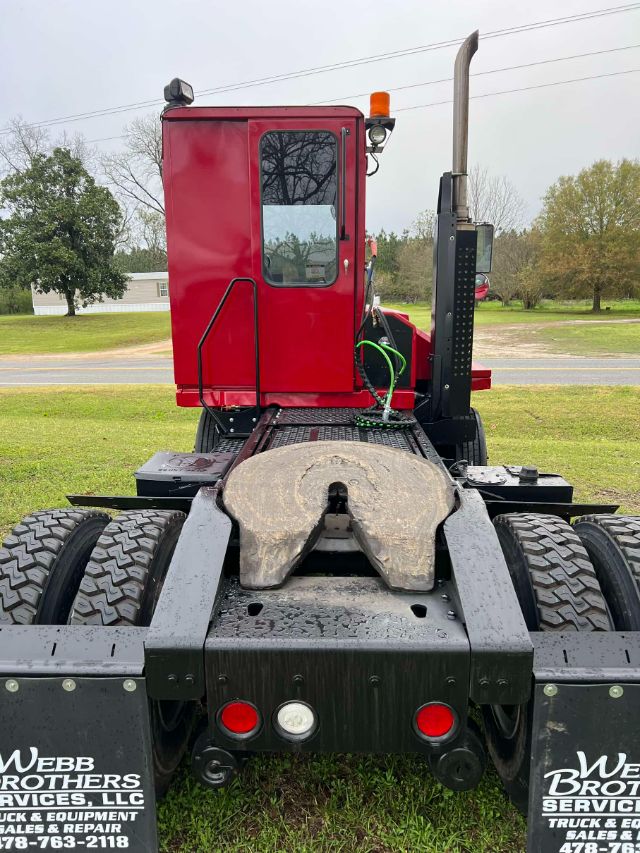 Kalmar Ottawa T2 yard truck chassis with red cab and fifth wheel, rear view shows dual rear axles and bumper lights.