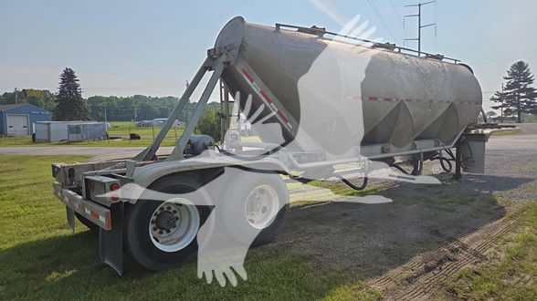 Fruehauf cement tank trailer in-service with cylindrical steel tank on a dual-axle tractor trailer chassis; rear lights and support frame visible.