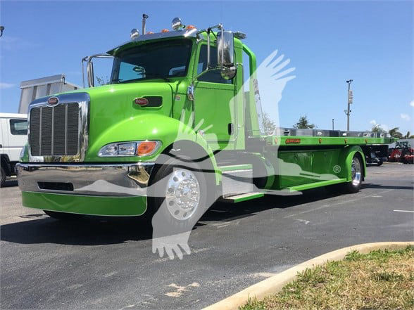 Peterbilt 337 tow truck in lime green with long flatbed, front chrome bumper, chrome grille, dual side mirrors, and black-tinted windows.