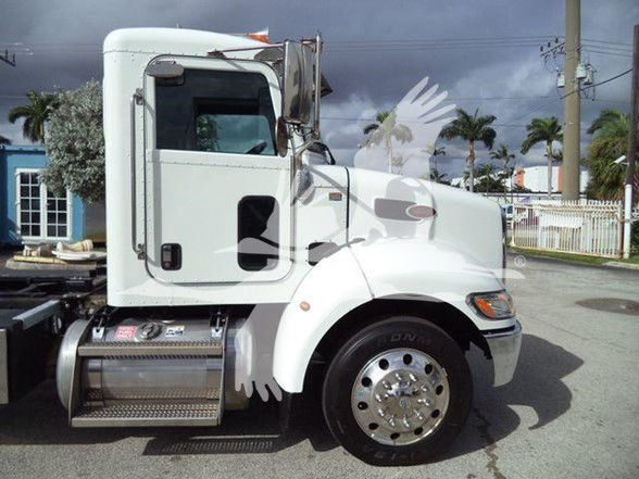Peterbilt 337 truck side view showing white cab and cylindrical fuel tank under door.
