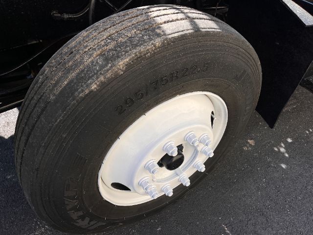 Wheel of a Kalmar Ottawa yard truck showing tire with tread and white steel wheel; lug nuts visible.