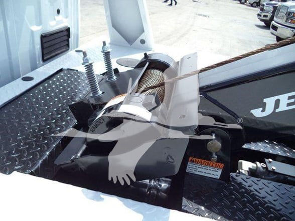 Tow truck setup with hook and winch on a diamond plate bed. Visible label reads WARNING; other equipment components but no clear model text.