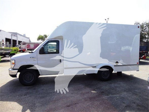 Box truck side profile showing 2015 Ford E350 SD with white cargo body and gray graphics and logo in a dealership lot.