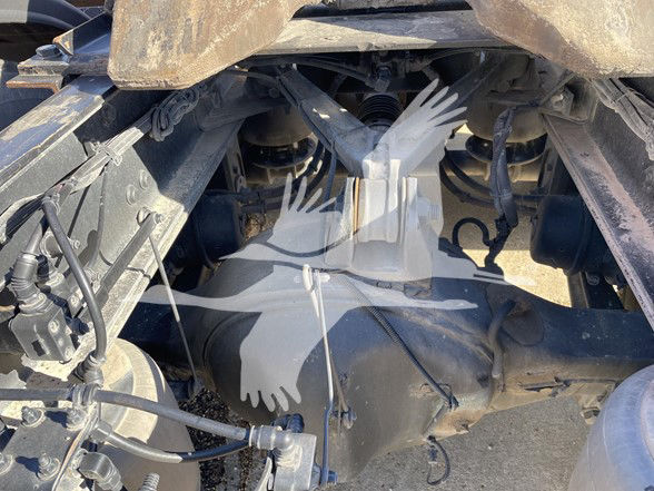 Kenworth T800 chassis underside showing rear differential and suspension components with hoses and wiring.