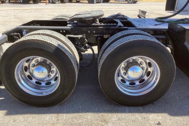 Peterbilt 579 truck chassis with dual rear axles and chrome wheels showing hubcaps.