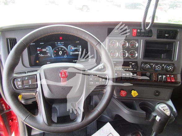 Kenworth W990 truck interior showing steering wheel, instrument cluster, and dashboard with gauges and control panel.