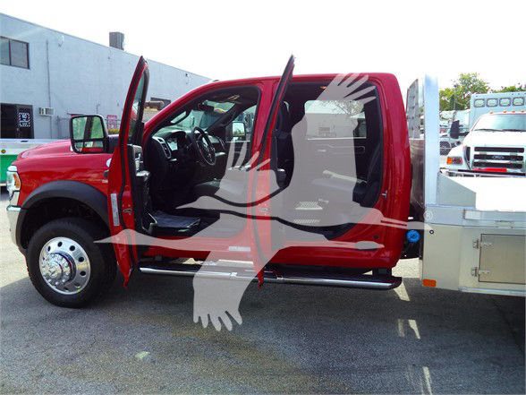 Ram 5500 SLT flatbed truck with open front door and extended cab. Side view shows red body, black interior, chrome wheel covers. Flatbed equipment visible on rear right.