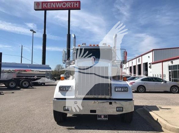 Kenworth W900L truck front view showing large grille and headlights in a dealership lot.