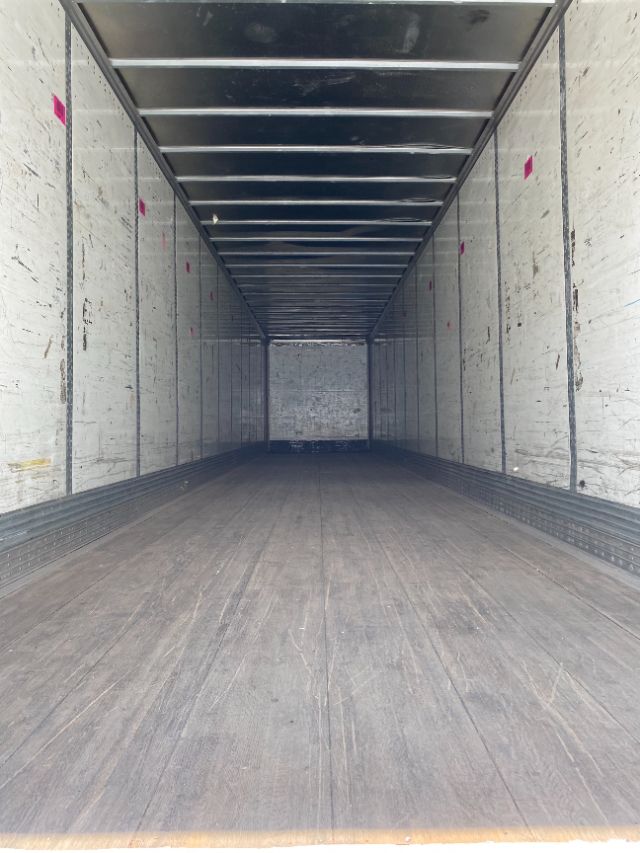 Interior of a Wabash Duraplate trailer cargo area with wooden floor and vertical sidewall panels.