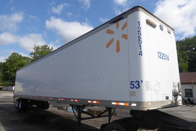 Great Dane trailer in a parking lot showing side and rear with 53' length and blue numbers, white exterior.