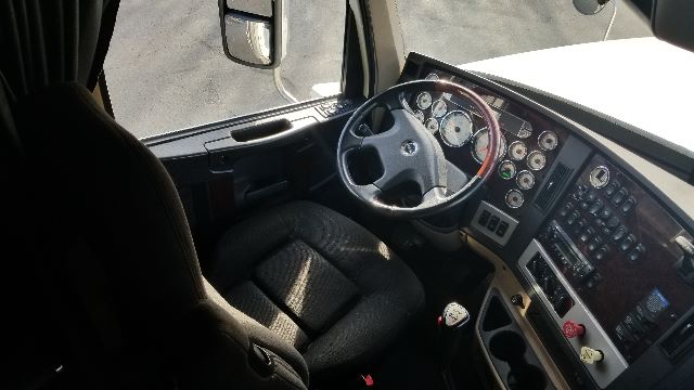 Freightliner Coronado 132 truck cockpit with steering wheel, gauges, and control panel visible.
