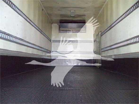 Trucked trailer interior with ribbed side rails and a raised floor view from the rear, no legible labels or stickers visible.