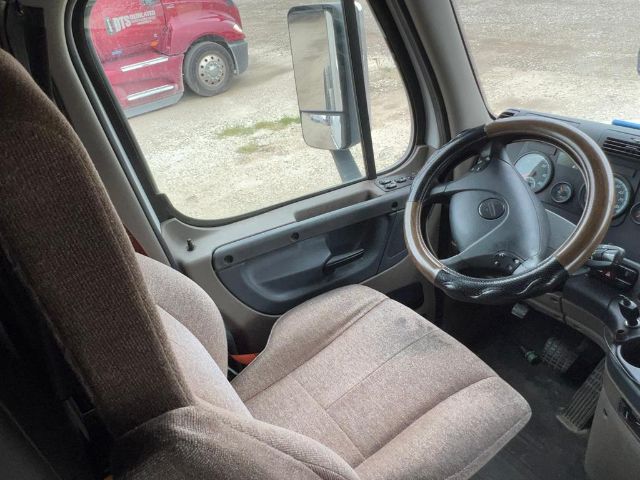 Cab interior of a 2017 Freightliner Cascadia showing steering wheel, dashboard gauges, and driver seat.