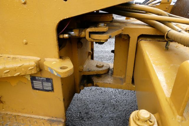 Bomag BW212D-2 undercarriage showing yellow steel frame and mounting pad.