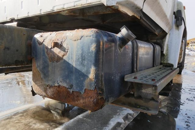 Fuel tank and undercarriage of a 2007 Hino 145 cab and chassis showing rust on the tank and side step.