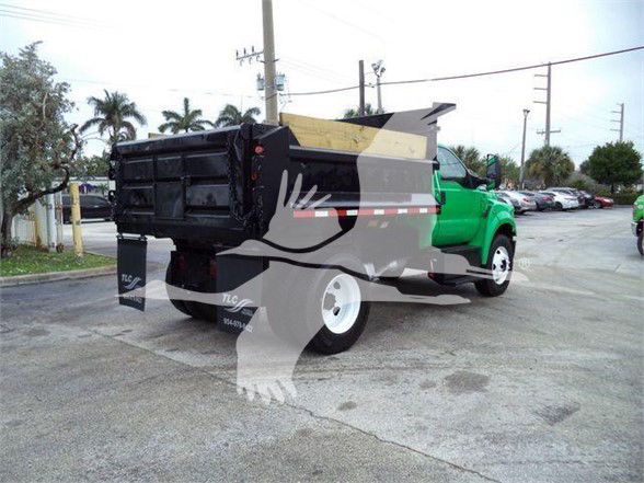 2017 Ford F650 SD dump truck with green cab and black dump bed, side view showing rear wheels and tailgate.