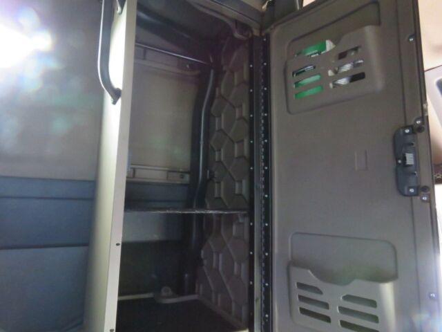 Interior of Freightliner Cascadia Evolution cab area with storage compartments and ventilation grille on door.