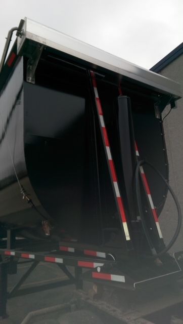 Dump trailer showing bottom view with circular structure and hydraulic hoses on a 2009 Great Dane round bottom semi-trailer.