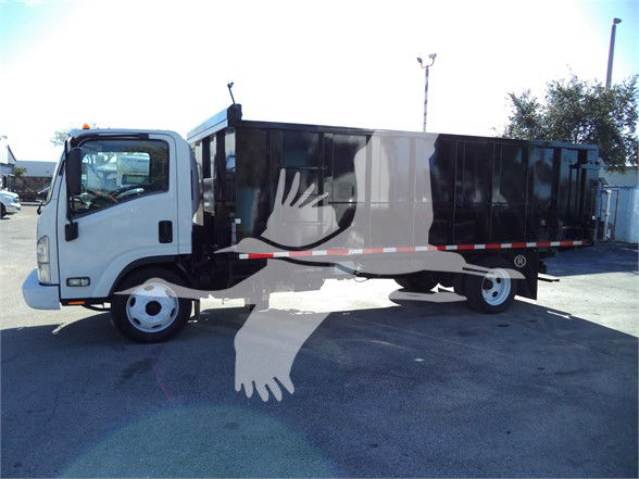 Isuzu NRR dump truck side view with black dump body, white cab, and orange safety beacon on roof. Stock number 18FTDUMPNRRFM visible in listing header area.