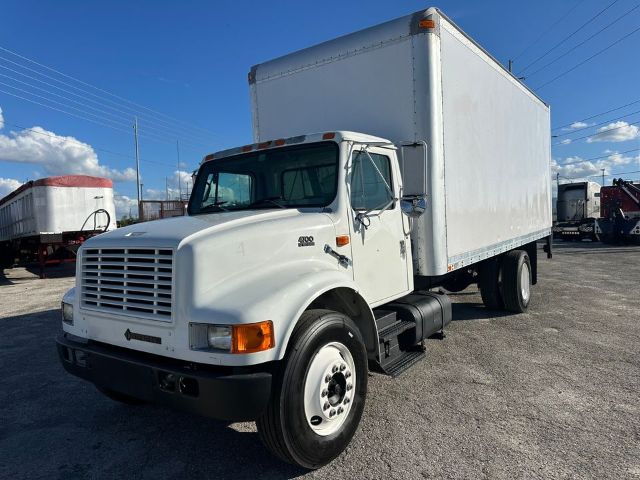 1997 International 4700 box truck with cab and box body, white exterior, front grille, dual rear wheels, and cargo box.