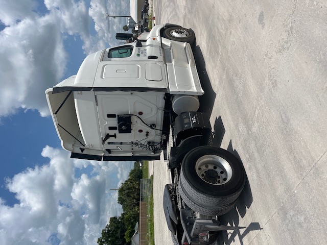 Truck cab rear view of a 2016 Freightliner Cascadia conventional sleeper tractor, white exterior, exposed fifth wheel area, with twin rear wheels.