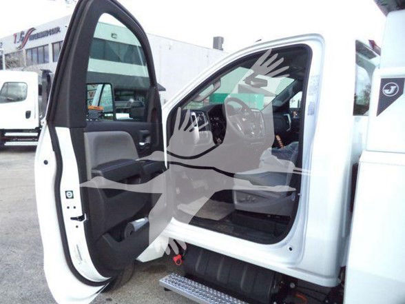Truck cab interior with open driver door showing steering wheel, dashboard, and side steps. Photo includes CHV6500MPL40 stock tag text faintly visible.