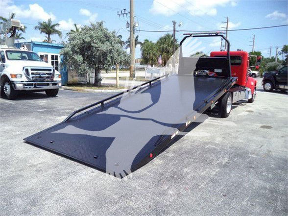 2021 Peterbilt 337 tow truck with a long flatbed ramp in a parking lot.