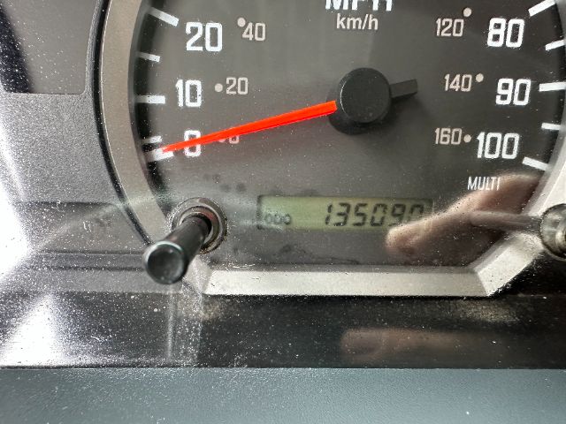 Dashboard gauge cluster showing speedometer with red needle and an odometer reading 135090. The display area includes faint text and a small digital odometer. 