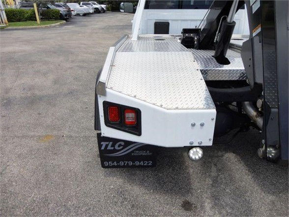 Ram 4500 Tow truck rear with aluminum diamond plate bed and TLC branding, rear taillights, bumper, and wheel well visible.