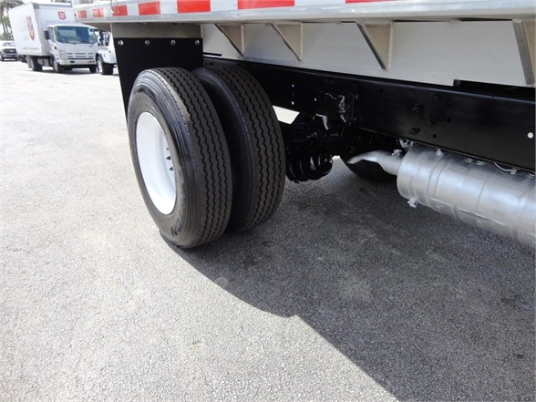 Freightliner Business Class M2 106 rear dual tires and side exhaust undercarriage view with black chassis and white wheel rims.