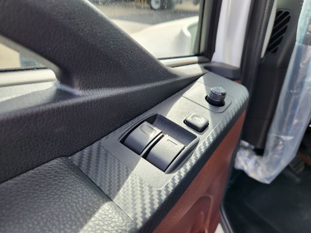 Vehicle interior door panel showing window switches and a small control knob.