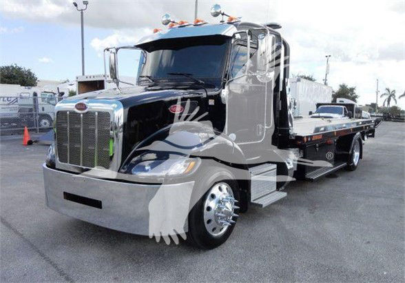 Peterbilt 337 tow truck in black with chrome accents and flatbed, front grille and headlights visible.