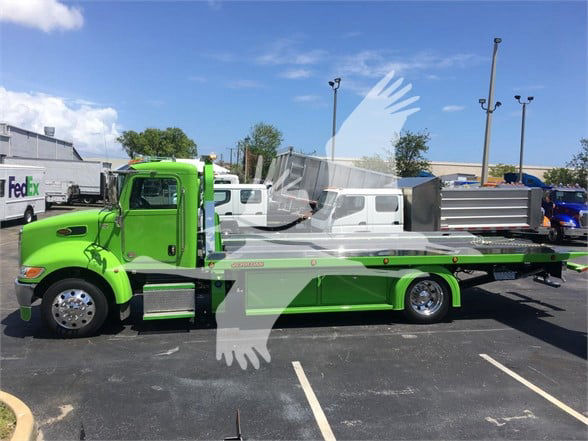 2022 Peterbilt 337 tow truck in green with flatbed, side view showing wheels and cab, stock number J52310.
