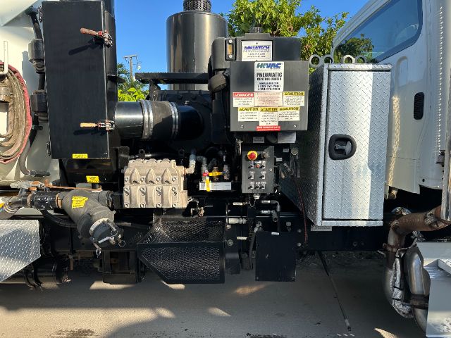 Freightliner M2 truck side view with yellow and black Pneumatic equipment, control panel, metal diamond-plate toolbox, hoses, and engine components.