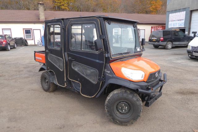Kubota RTV-X1140 utility vehicle in black and orange, side view showing cab enclosure and rugged tires.