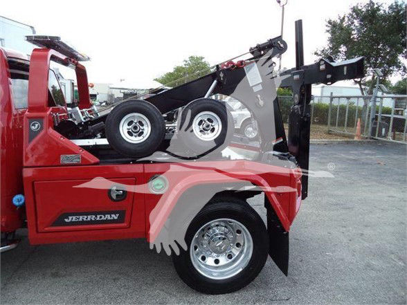 Ram 5500 tow truck focusing on rear wheel and deck with a spare tire on the bed.