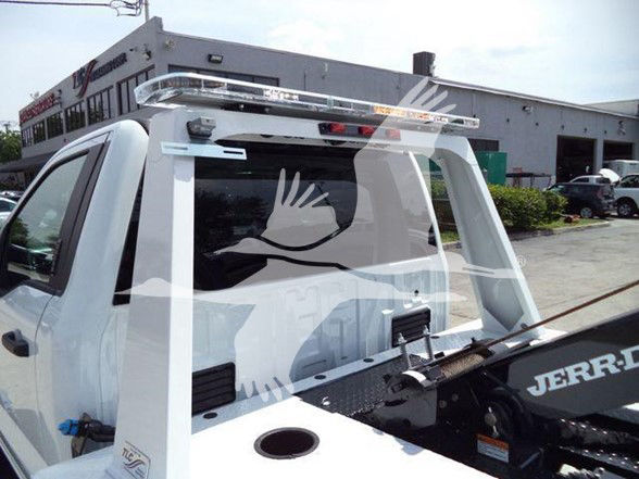Ford F-450 dump tow truck pickup bed with roll bar and light bar, rear window visible, Jerr-Dan equipment in bed.