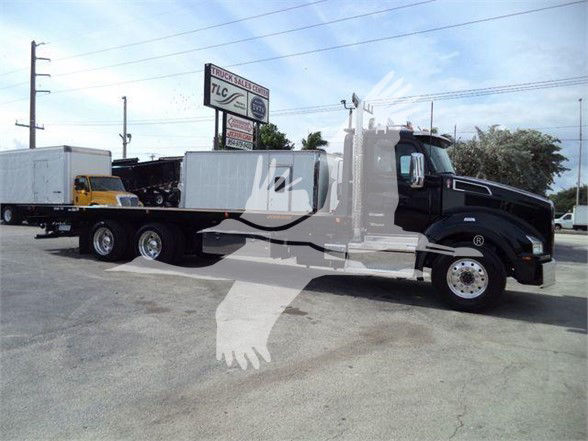 Kenworth T880 tow truck with long wheelbase, black cab, flatbed equipment in background. Stock number KWT880HD15T visible on listing.