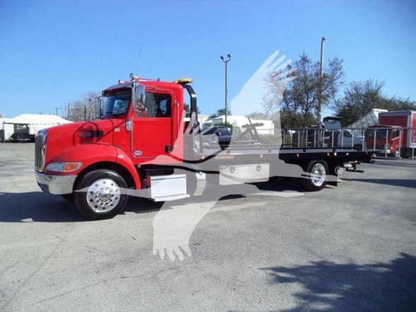 Peterbilt 337 tow truck in red with flatbed, side view showing cab and long bed.