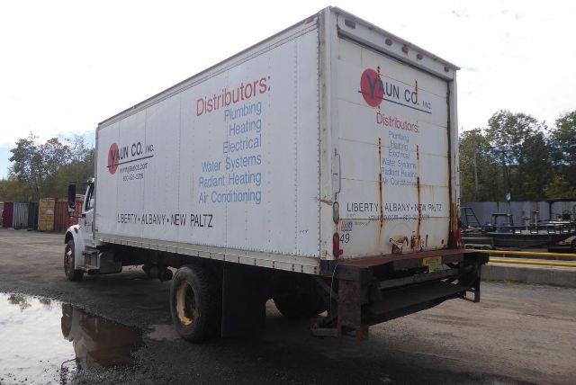 Freightliner M2 106 box truck with rear roll-up door, company graphics on side listing services (plumbing, heating, electrical, air conditioning).