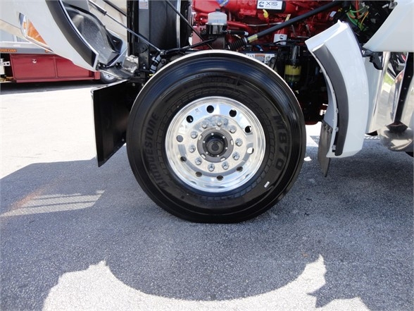 Kenworth W900 wheel and front fender area showing Bridgestone tire and polished aluminum wheel.