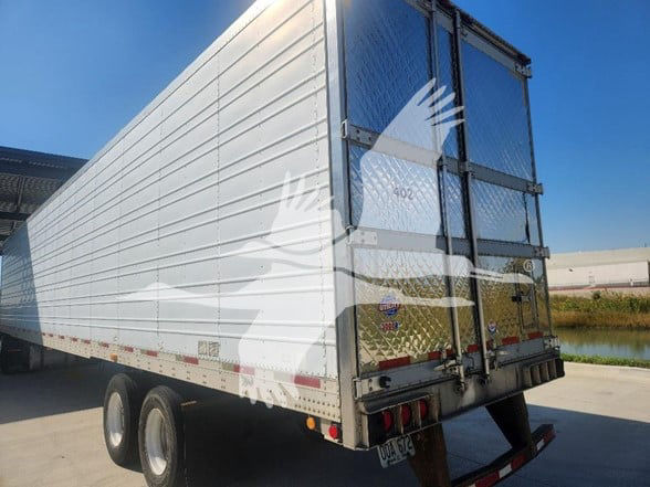 Trailer rear and side view of a 2006 Utility 3000R reefer trailer with aluminum sides, dual rear doors, diamond plate lower rear panel, and stock number 402 visible.