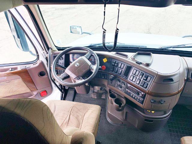 Volvo VNL 670 truck interior cockpit showing steering wheel and dashboard with numerous controls and switches.