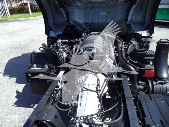 Isuzu NPR HD engine bay showing exposed drivetrain and components.