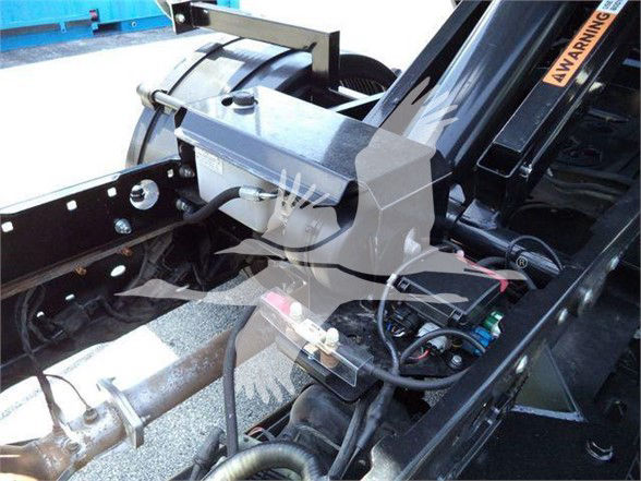 Ford F-Series chassis showing hydraulic reservoir and European-style mounting brackets in a truck bed area.