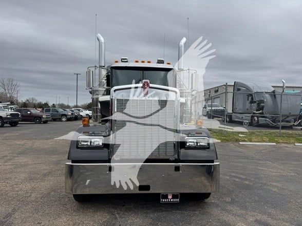 Kenworth W900L conventional sleeper truck front view with large chrome grille and dual exhaust stacks.