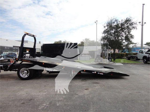 Tow truck on a flatbed with a watermark overlay. No legible labels or text visible on the vehicle components.